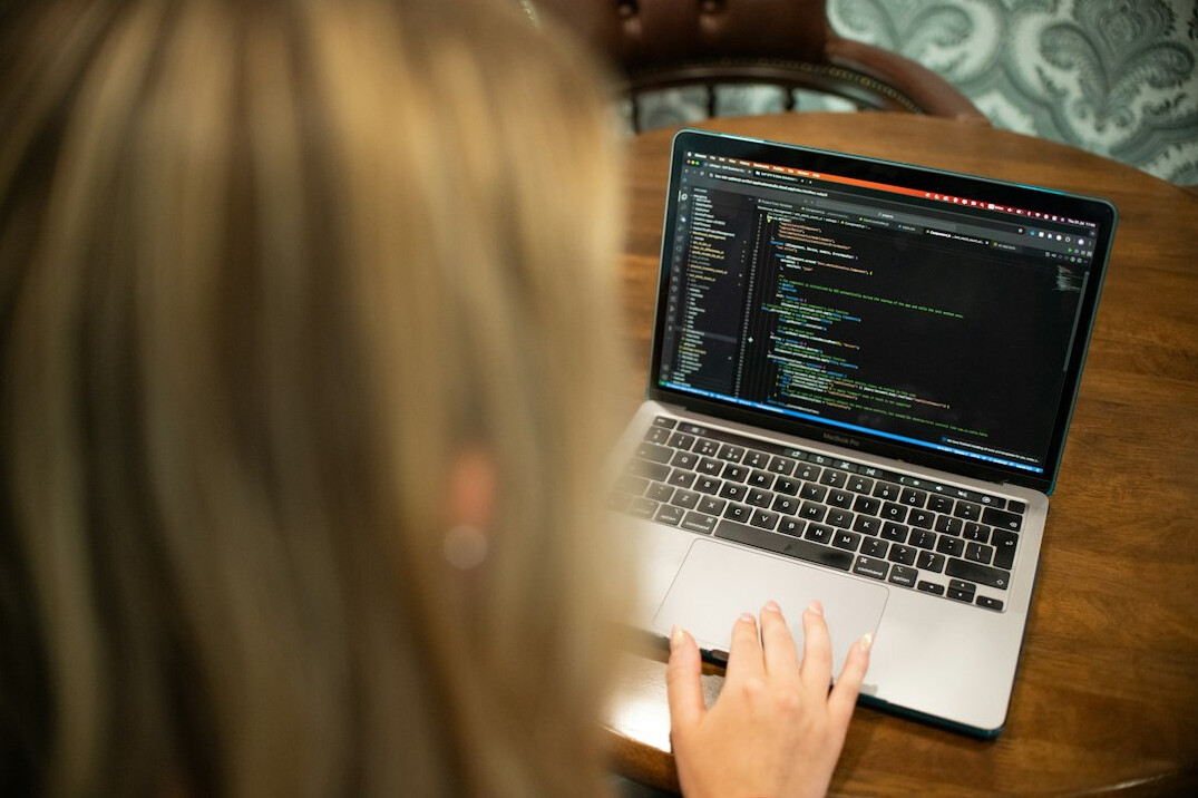 young person coding on laptop